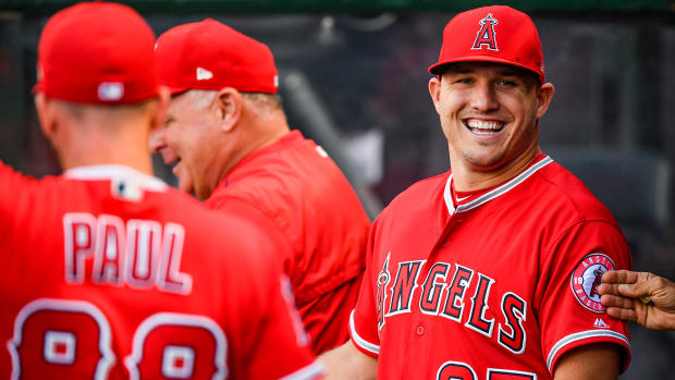 Mike Trout smiles while in the Angels dugout